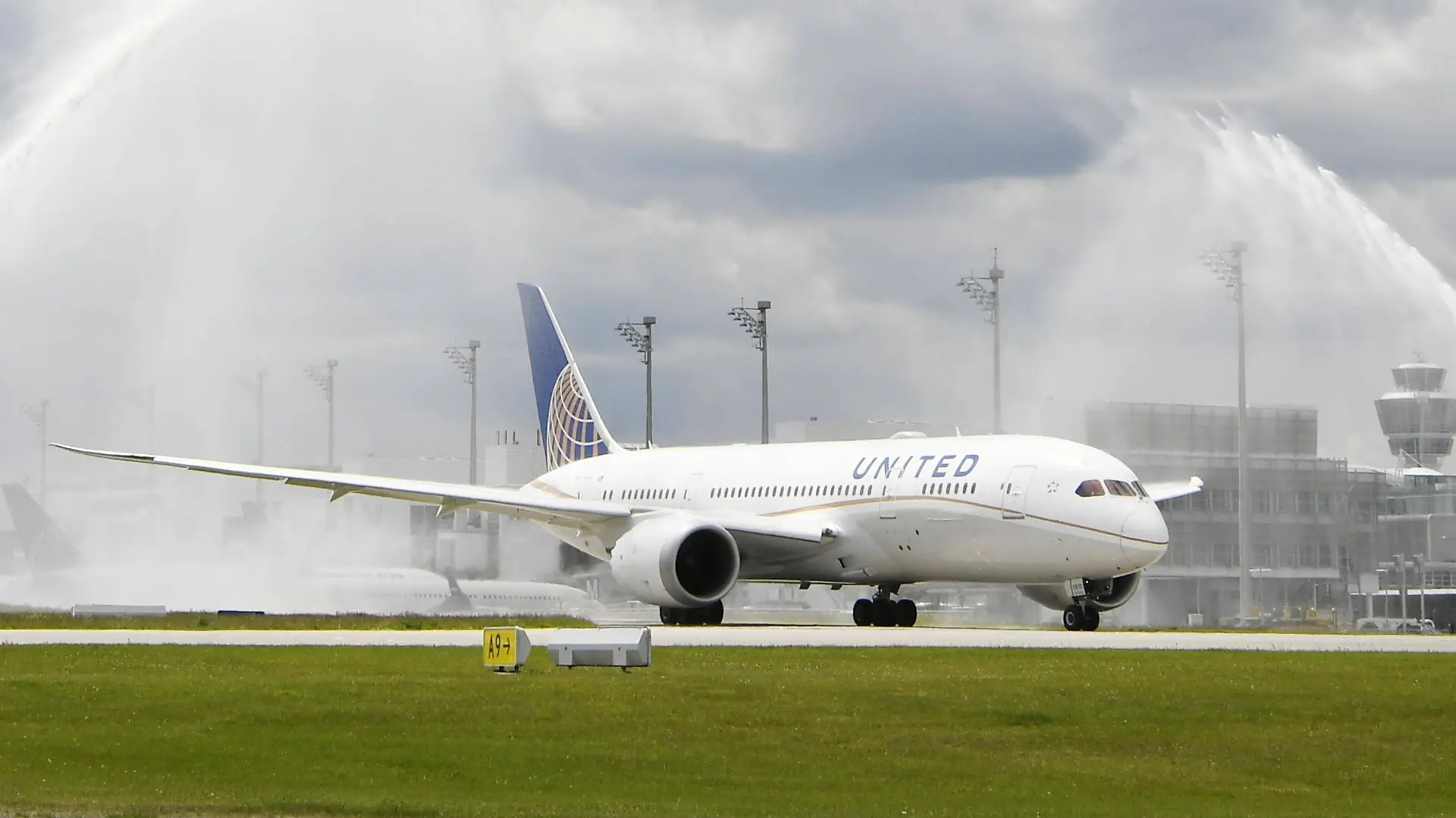 Ein Dreamliner (Boeing 787) von United Airlines bekommt nach seiner Erstlandung am Flughafen München eine Wassertaufe von der Flughafenfeuerwehr.