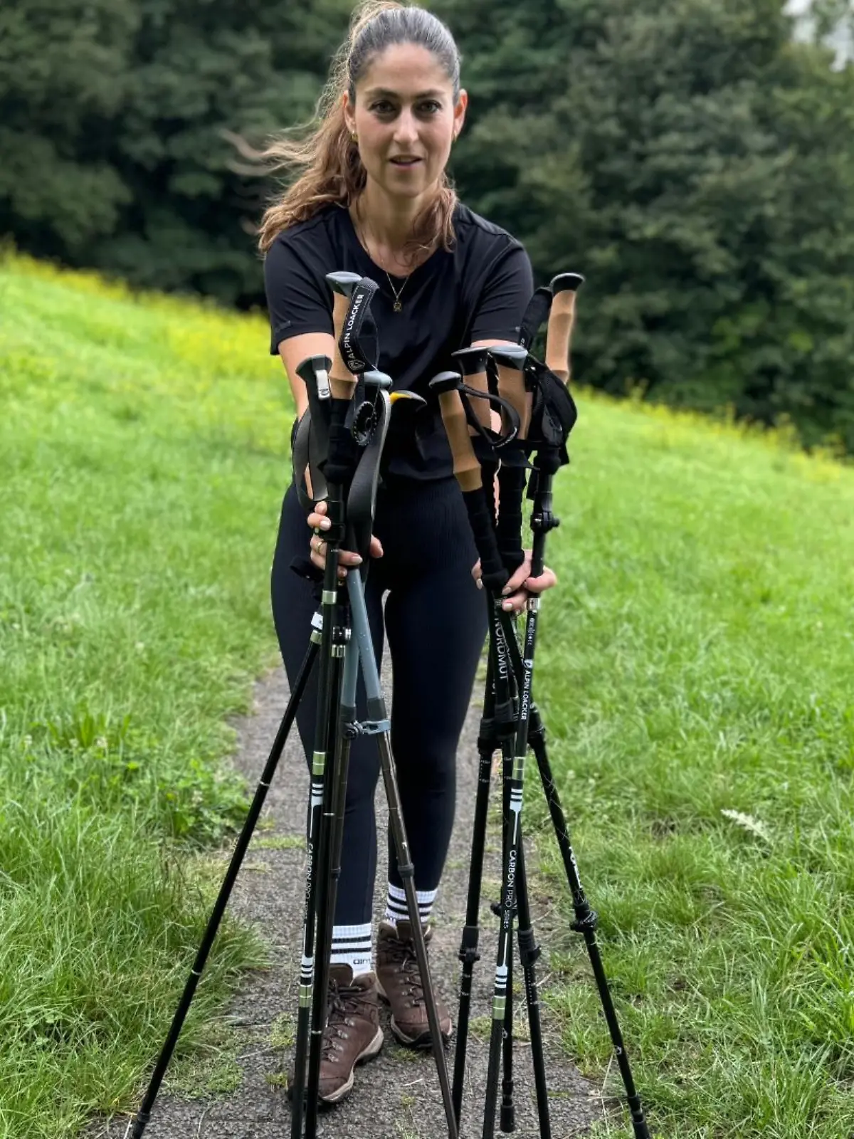 Reporterin mit Wanderstöcken im Wald.