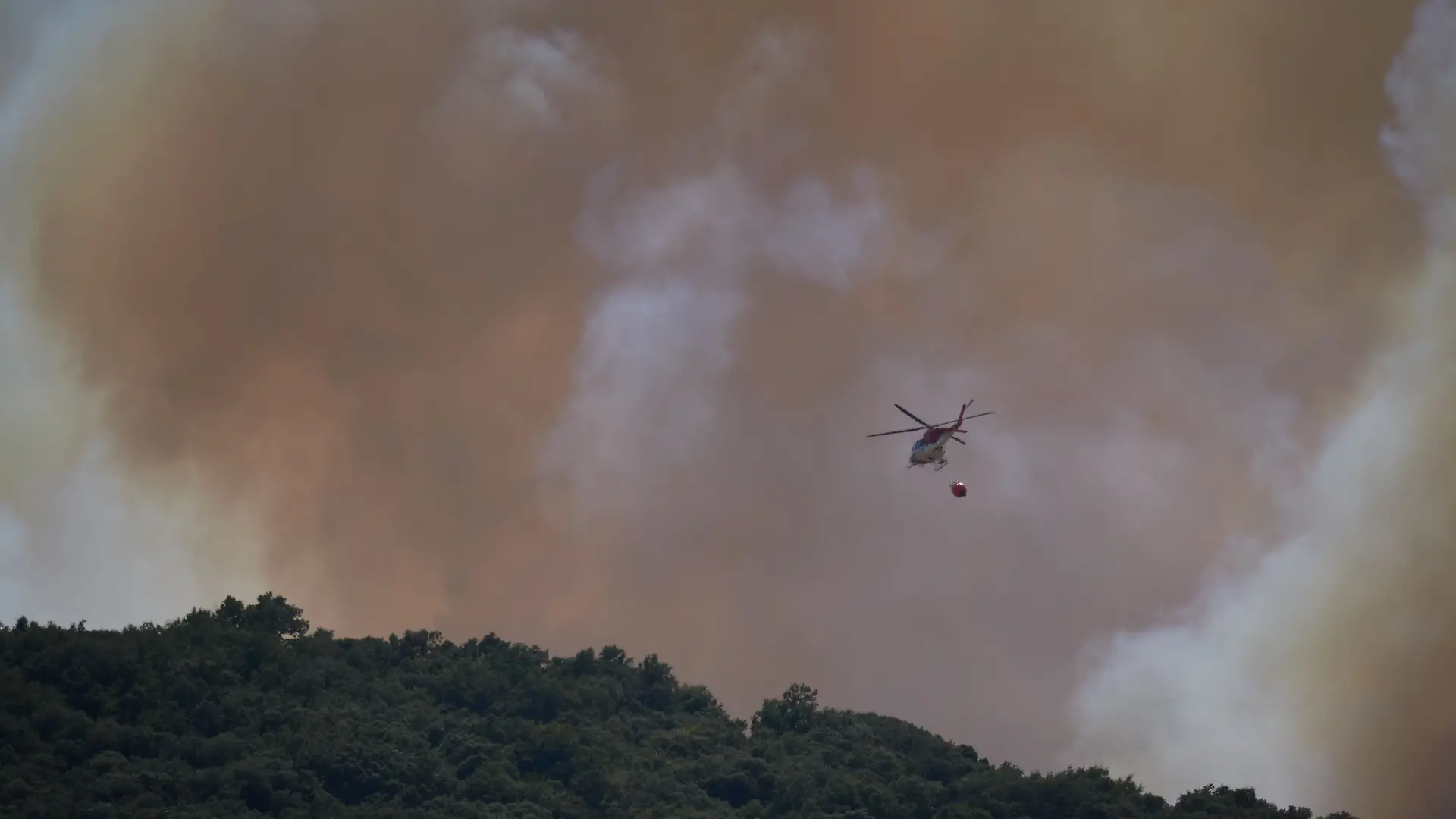 Ein Löschhubschrauber ist während eines Waldbrandes im Einsatz.