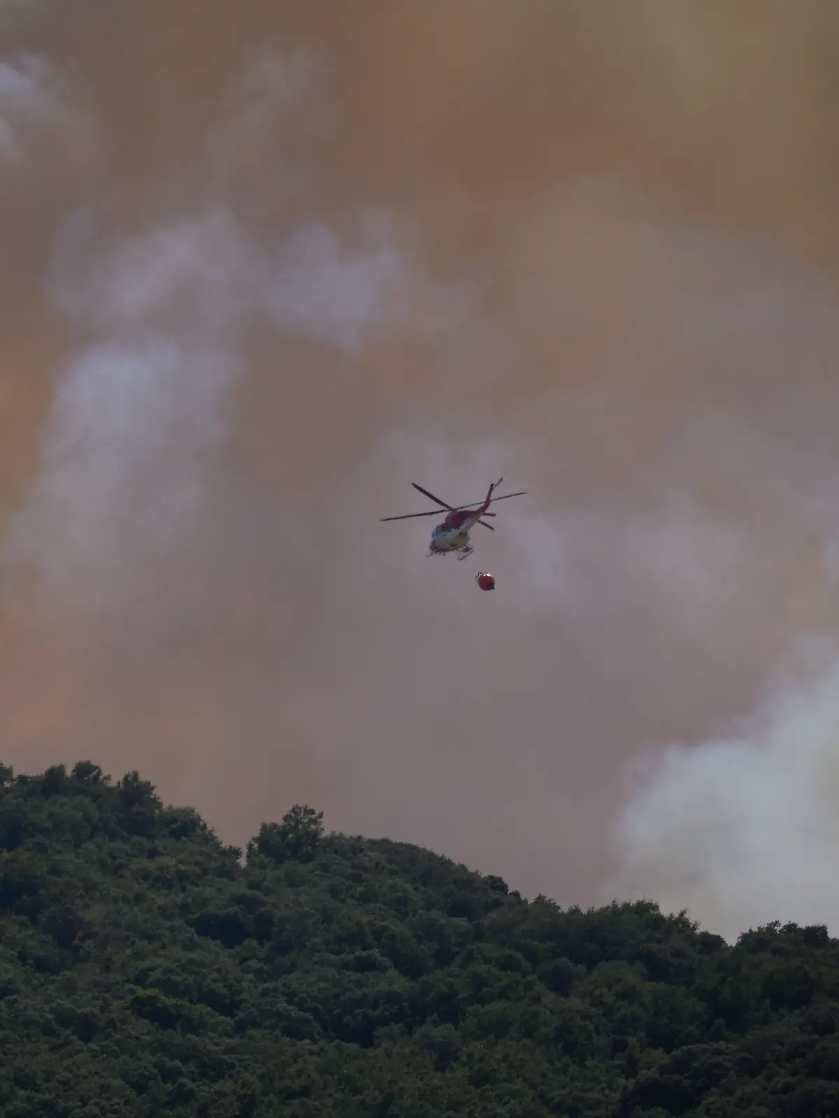  Ein Löschhubschrauber ist während eines Waldbrandes im Einsatz. 