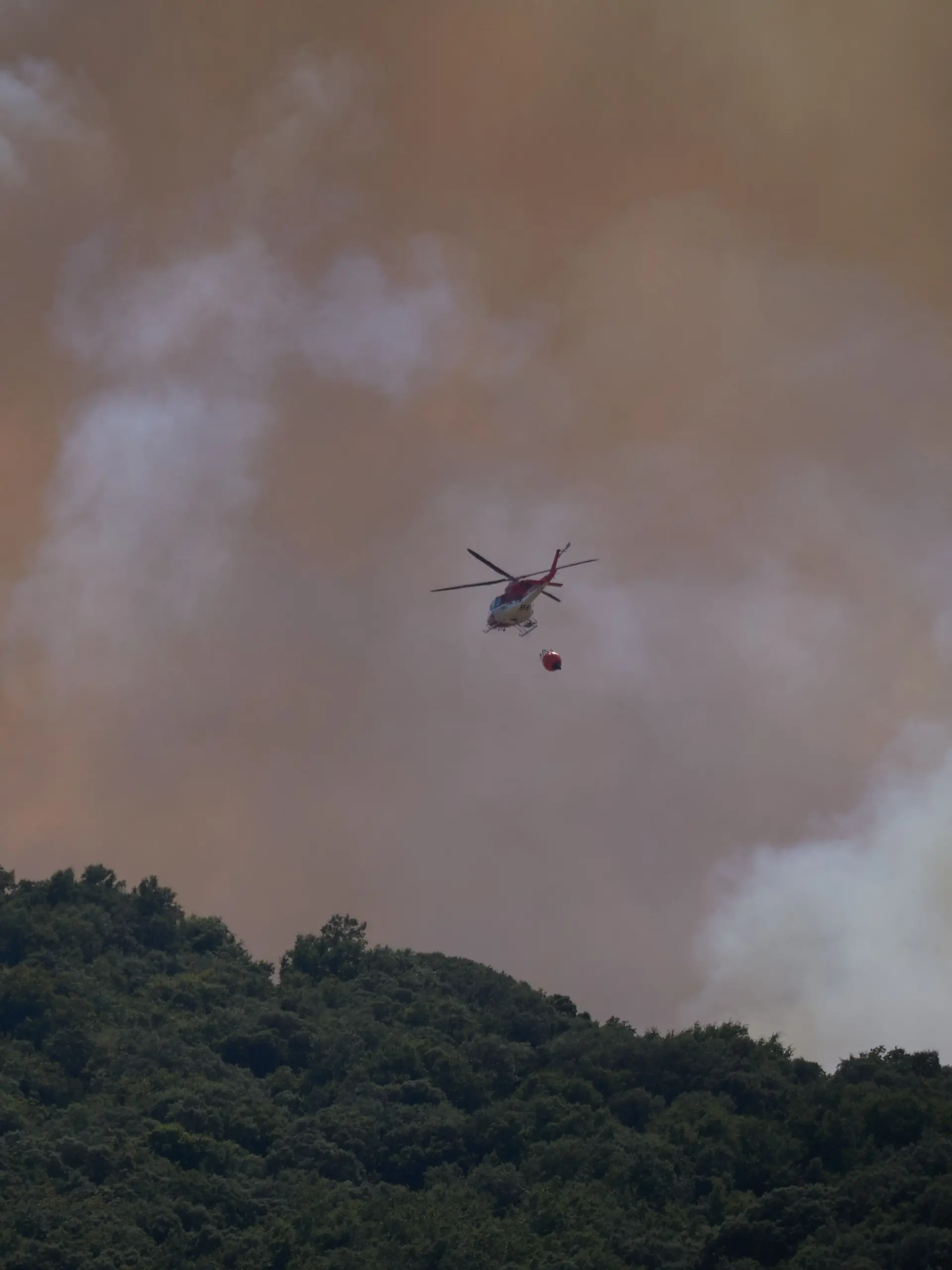  Ein Löschhubschrauber ist während eines Waldbrandes im Einsatz. 