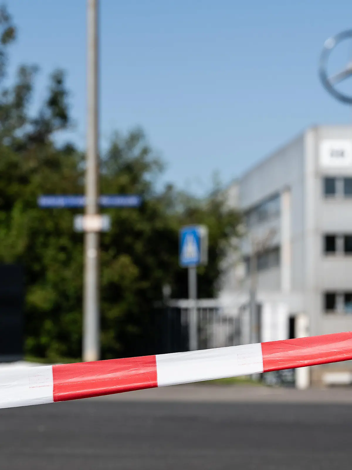 11.08.2023, Hessen, Kassel: Absperrband hängt am Eingang zum Firmengelände. In Kassel hat am Freitagmorgen die Evakuierung des Sperrkreises rund um eine amerikanische Bombe aus dem Zweiten Weltkrieg begonnen. «Nach erfolgter Evakuierung beginnen die vorbereitenden Arbeiten für die Sprengung durch den Kampfmittelräumdienst. Unter anderem muss die Bombe dazu auch verlagert werden», teilte die Stadt Kassel mit. Der 500 Kilogramm schwere Blindgänger war am Donnerstag bei Bauarbeiten auf dem Gelände des Mercedes-Benz Werkes im Stadtteil Rothenditmold gefunden worden. Foto: Swen Pförtner/dpa +++ dpa-Bildfunk +++