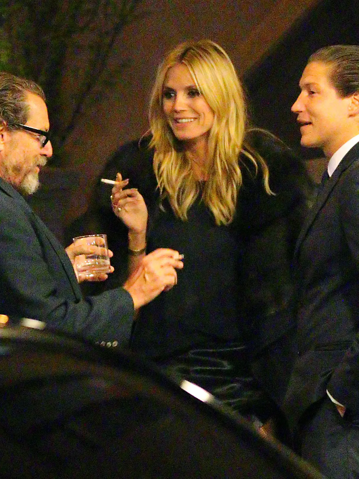 EXCLUSIVE: Things are getting serious! Heidi Klum licks her lips as she looks towards Vito Schnabel with a cigarette in hand, while Julian Schnabel looks on, during a break at the John Pizzarelli/Daniel Jobim performance at the Carlyle Hotel in NYC on April 17, 2015.