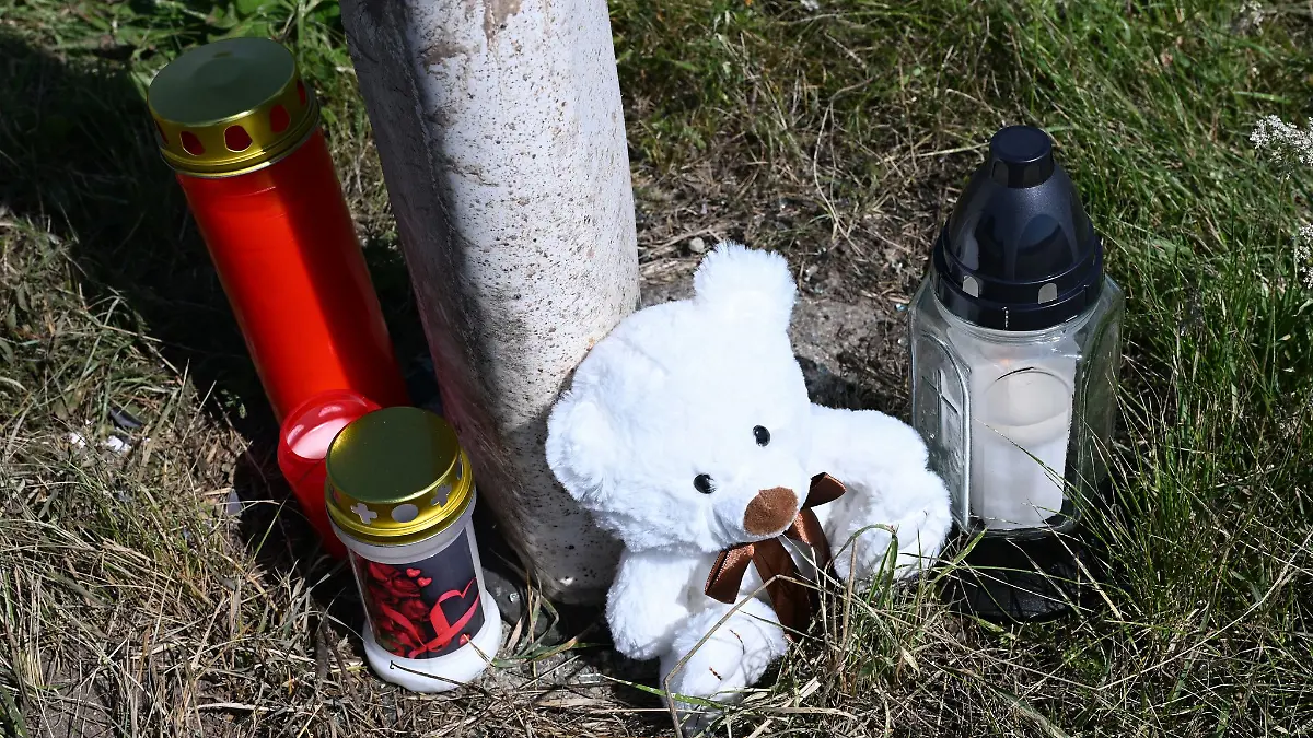 Menschen haben Kerzen und einen Teddybären an der Unfallstelle abgestellt.