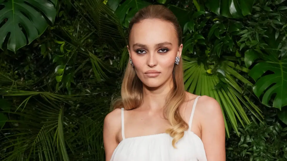 Schauspielerin Lily-Rose Depp schaut in typischer roter Teppich-Pose mit kühler Miene in die Kamera. (Archivbild)