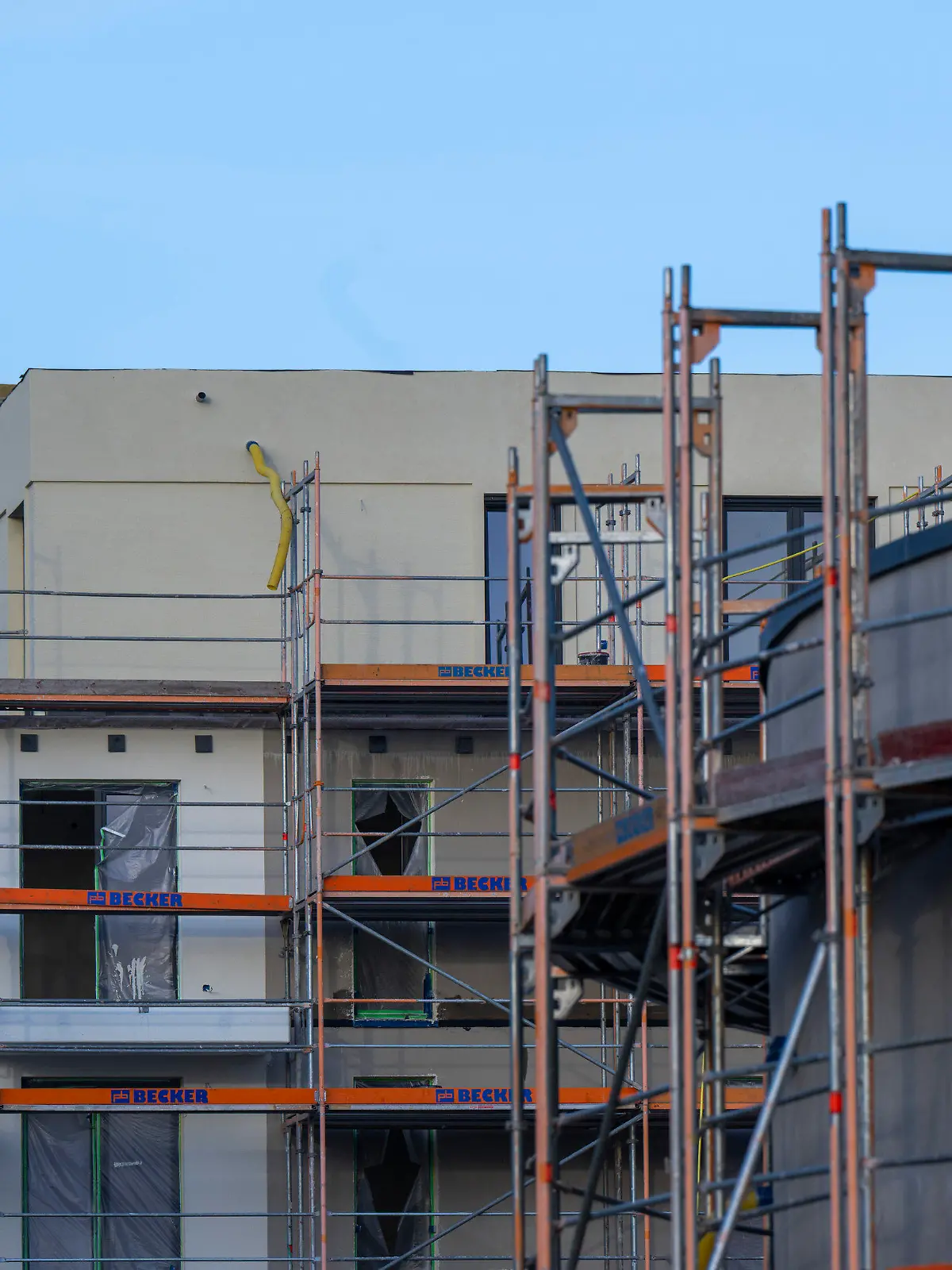 ARCHIV - 28.10.2022, Berlin: Ein Baugerüst steht an der Fassade von einem nicht fertig gebauten Wohnhaus auf einer Baustelle im Berliner Süden. Die deutsche Bauwirtschaft warnt vor einem Einbruch im Wohnungsbau und fordert Unterstützung von der Politik. (zu dpa "Baubranche verlangt Erleichterungen für Wohnungsbau") Foto: Monika Skolimowska/dpa +++ dpa-Bildfunk +++