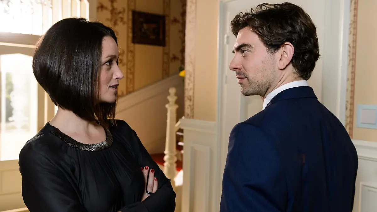 Leise drohend erinnert Jenny (Kaja Schmidt-Tychsen) Veit (Carsten Clemens) daran, dass sie ihn nicht dafür bezahlt, Richard zu beeindrucken, sondern um ihre Eltern zu ruinieren...