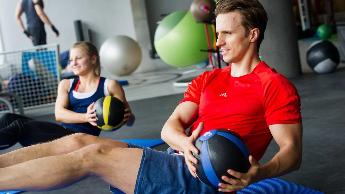 Mann und Frau machen im Fitnessstudio Russian Twists