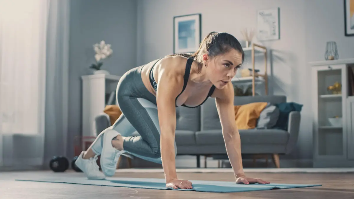 Junge Frau macht im Wohnzimmer Mountain Climbers