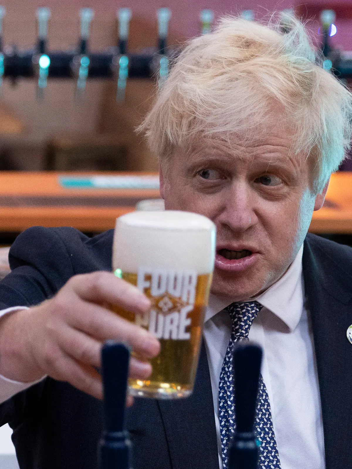 ARCHIV - 27.10.2021, Großbritannien, London: Boris Johnson, Premierminister von Großbritannien, hält bei einem Besuch in der Fourpure-Brauerei ein Bier in der Hand. Zum Feierabend auf zwei Pints in den Pub, das ist in Großbritannien seit langem für viele liebgewonnene Tradition. Die Kneipen sind Kontaktbörse und Informationsbasar. Aber «Partygate» macht deutlich: Alkohol ist auch ein Problem und das ist längst in der Downing Street selbst angekommen. (Zum dpa KORR zur Britischen Politik und dem Alkohol vom 22.1.2022) Foto: Dan Kitwood/PA Wire/dpa +++ dpa-Bildfunk +++