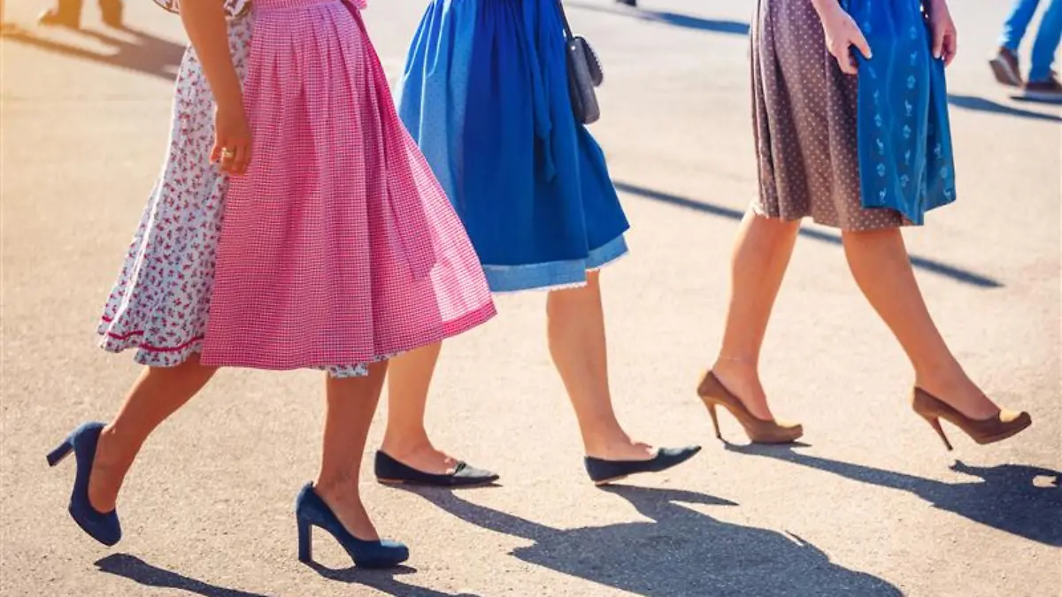 Drei Frauen tragen bunte Dirndl.
