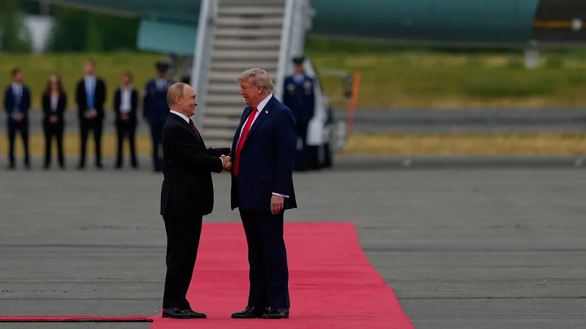 Trump und Putin begrüßen sich mit einem Handschlag.