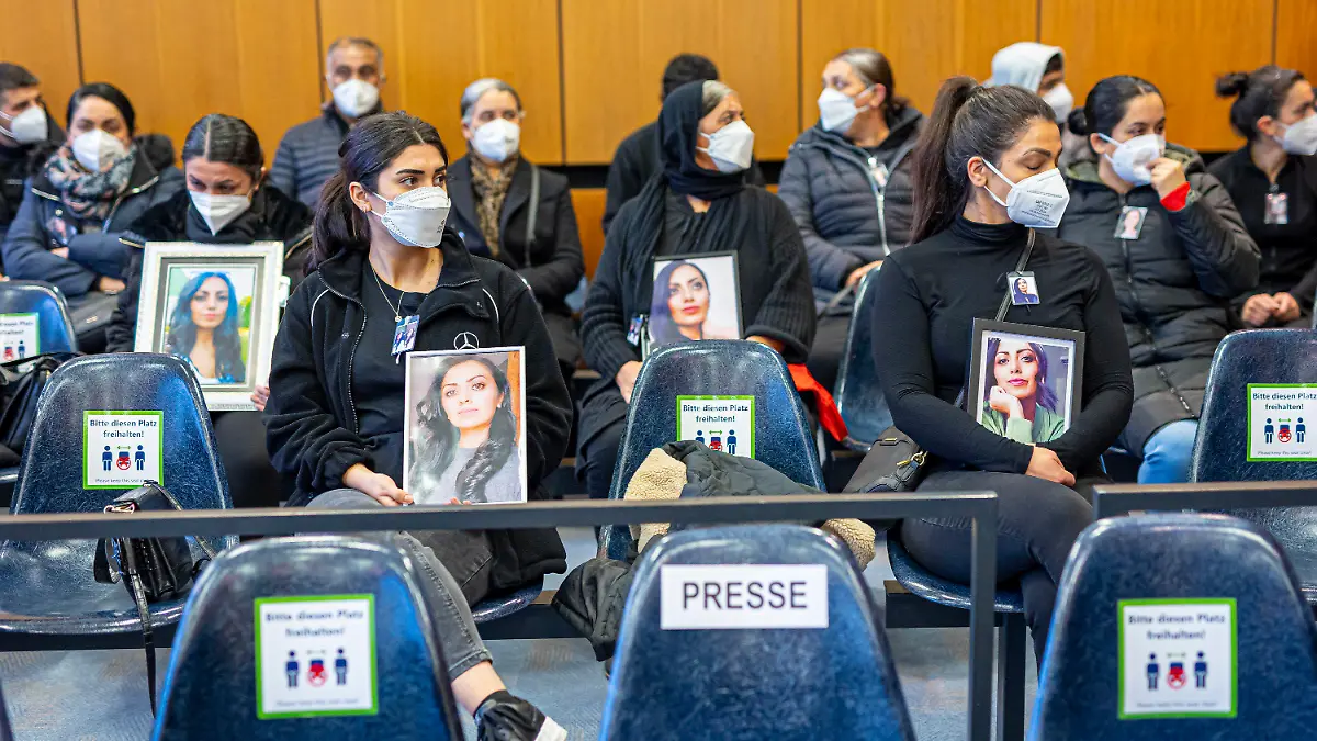 dpatopbilder - 14.10.2022, Niedersachsen, Hildesheim: Angehörige der Getöteten sitzen mit Porträtfotos der Frau bei Prozessauftakt in einem Saal vom Landgericht Hildesheim. Einem Angeklagten wird vorgeworfen, im Mai 2022 in Burgdorf (Region Hannover) seine Ehefrau aus niederen Beweggründen heimtückisch ermordet zu haben. Foto: Moritz Frankenberg/dpa - Nutzung nur nach schriftlicher Vereinbarung mit der dpa +++ dpa-Bildfunk +++