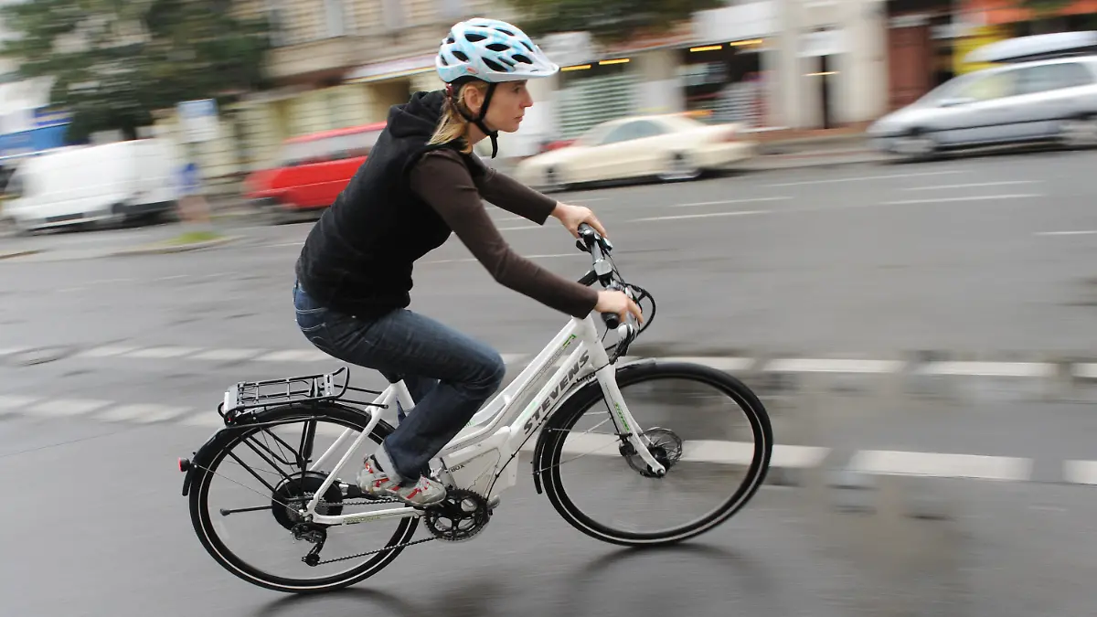 ARCHIV - Ein Elektrofahrrad bewegt eine mit einem Helm geschützte Fahrerin am 28.07.2011 durch Berlin. Foto: Rainer Jensen dpa (zu dpa: "SPD-Verkehrsexperte: Helmpflicht bei E-Rädern vorstellbar" vom 19.04.2014) +++(c) dpa - Bildfunk+++