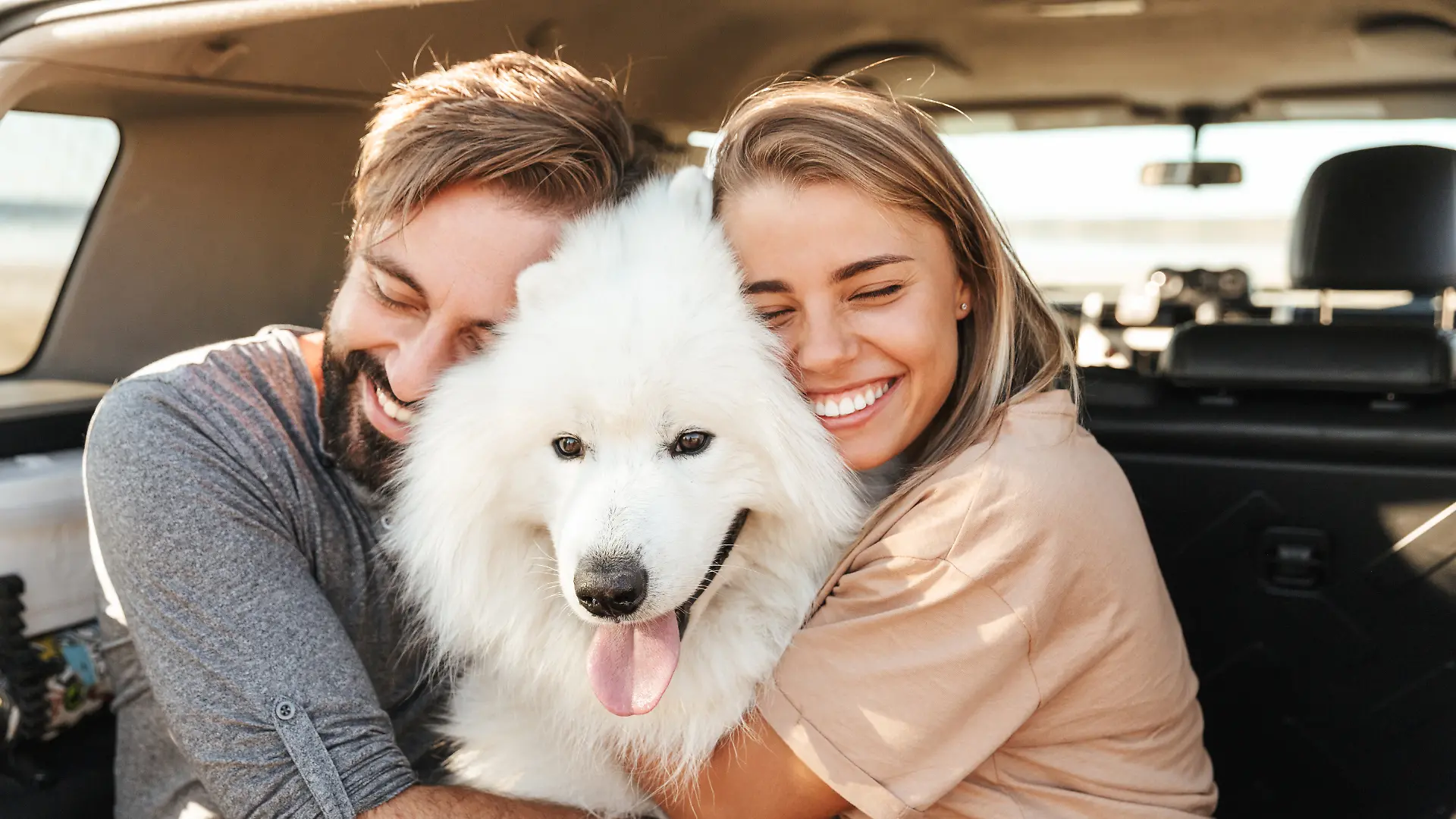Pärchen umarmt seinen Hund
