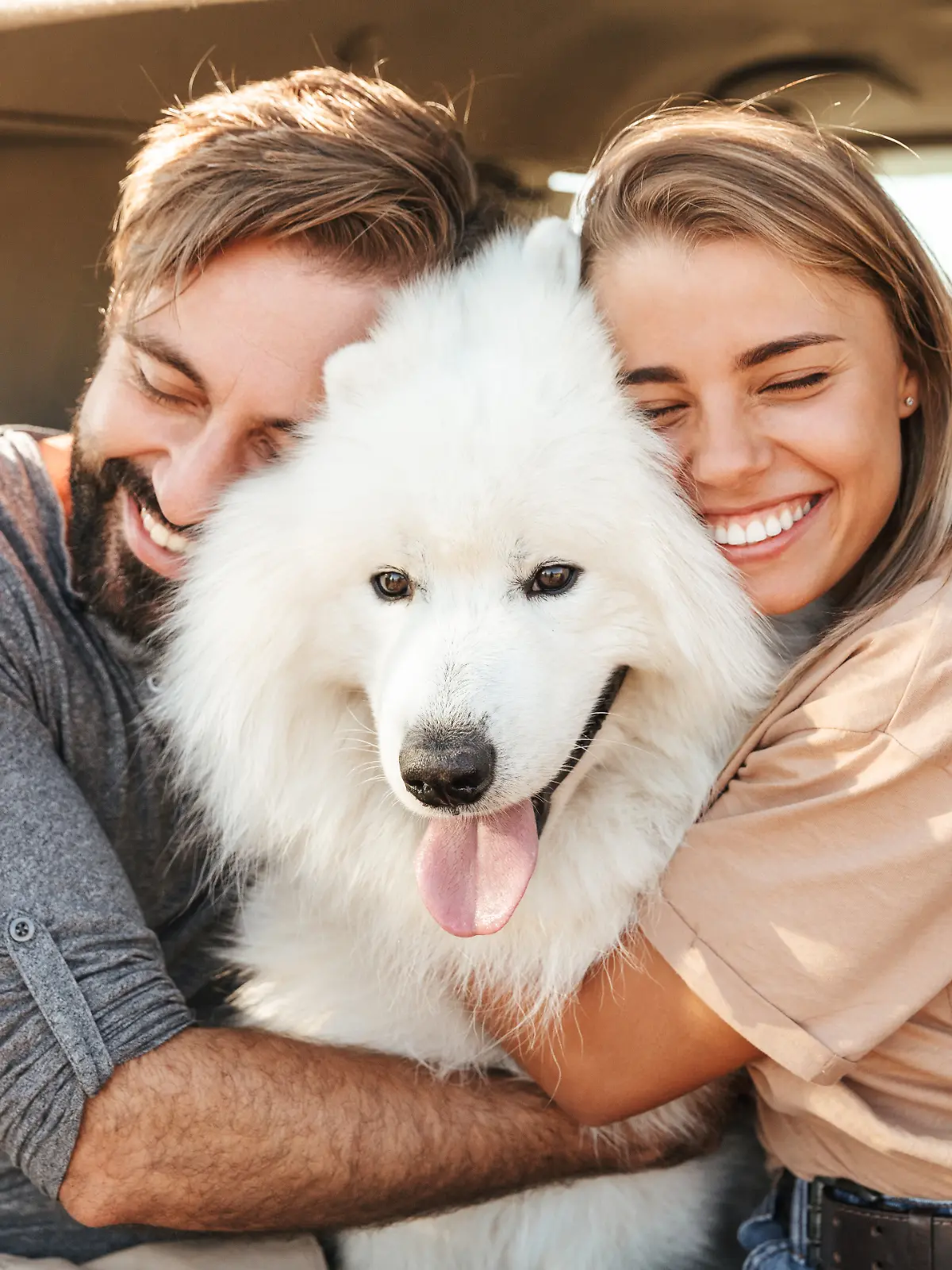 Pärchen umarmt seinen Hund