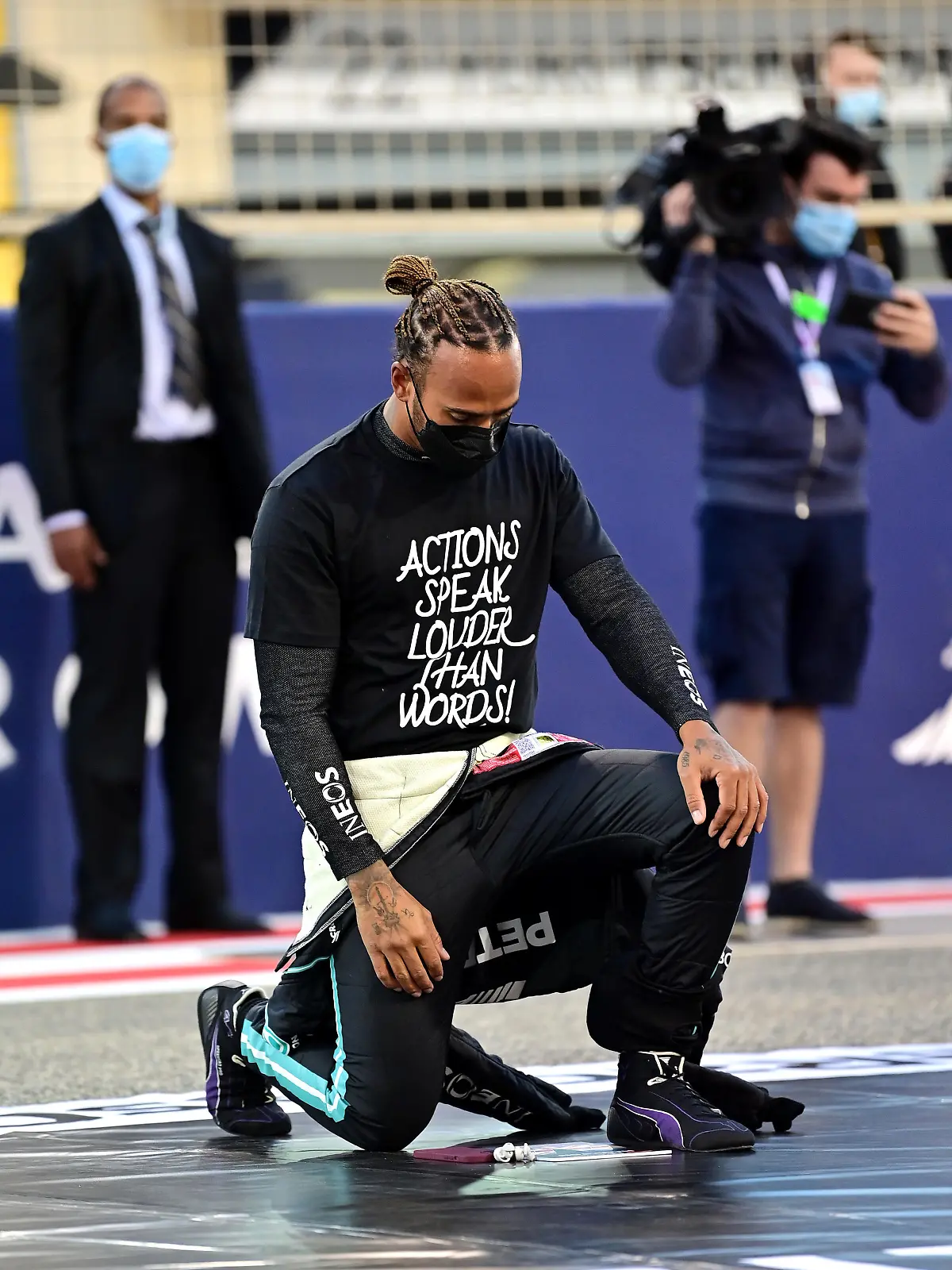 BAHRAIN, BAHRAIN - MARCH 28: Lewis Hamilton of Great Britain and Mercedes GP takes a knee on the grid in support of the Black Lives Matter movement prior to the F1 Grand Prix of Bahrain at Bahrain International Circuit on March 28, 2021 in Bahrain, Bahrain. (Photo by Andrej Isakovic -Pool/Getty Images)
