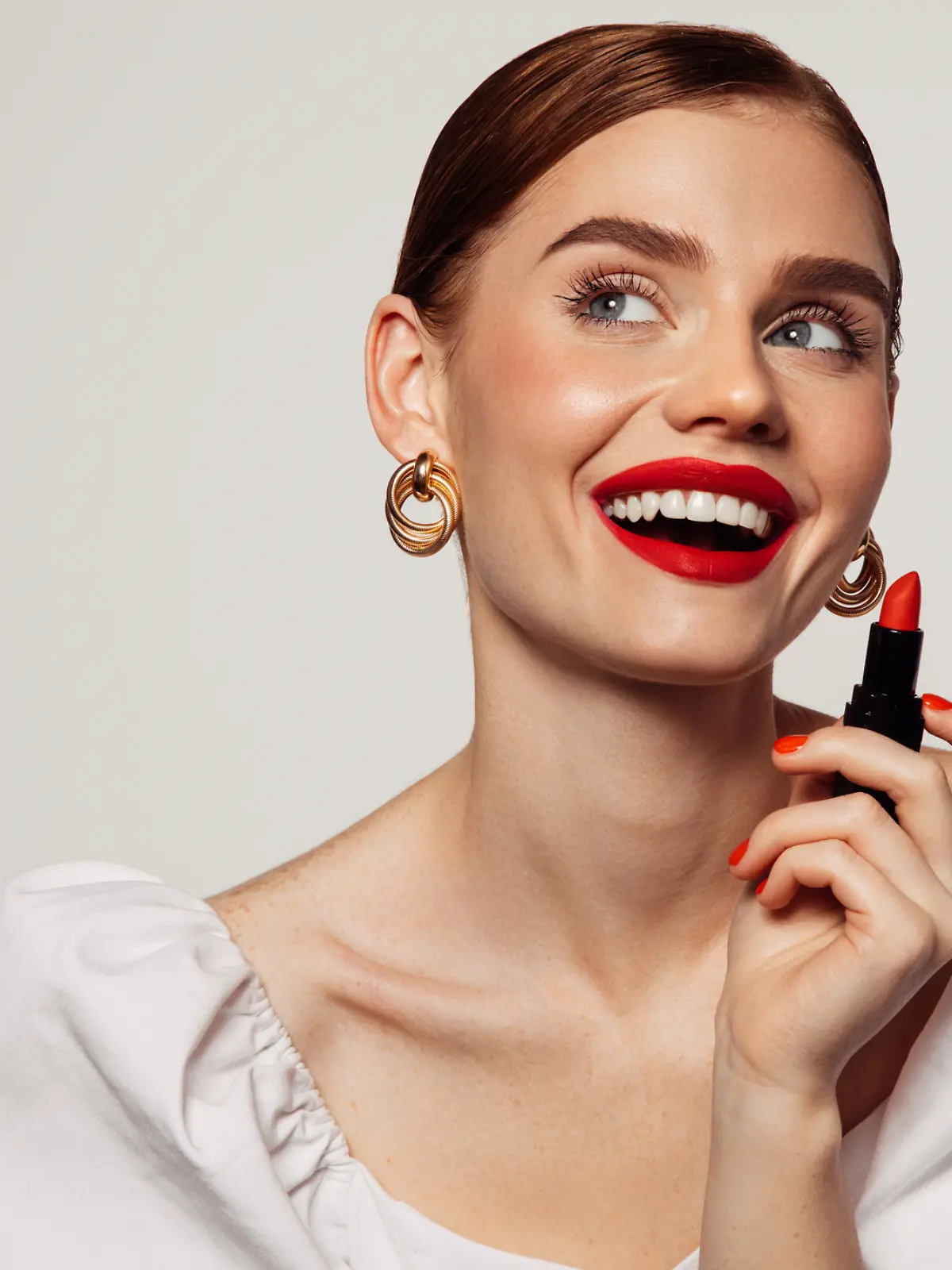 Frau ist geschminkt und trägt roten Lippenstift. 