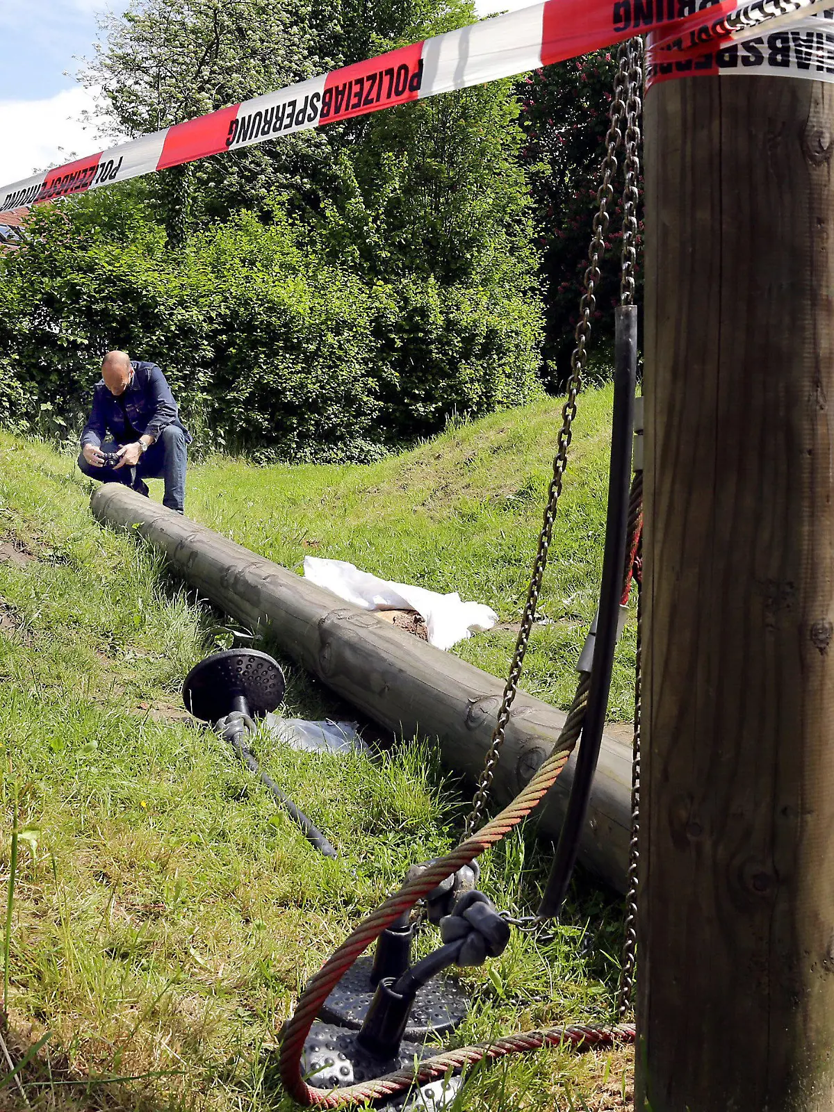 ARCHIV - Ein Ermittlungsbeamter untersucht am 27.05.2013 in Datteln (Nordrhein-Westfalen) eine gebrochene Spielplatz-Schaukel. Nach dem tödlichen Unfall auf einem Spielplatz in Datteln 2013 beginnt am Donnerstag der Prozess gegen einen städtischen Mitarbeiter wegen fahrlässiger Tötung Eine 18-Jährige war im Mai 2013 von einem Schaukelgerüst erschlagen worden, weil ein Pfosten morsch war. Im Prozess geht es u.a. um die Frage, ob der Platz ausreichend kontrolliert wurde.    Foto: Andreas Kalthoff/Dattelner Morgenpost/dpa +++(c) dpa - Bildfunk+++