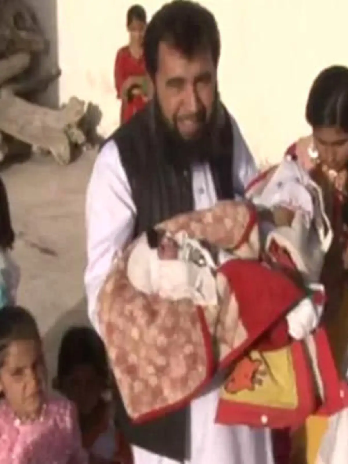 Story from Jam Press (60 Children)

Pictured: Sardar Jan Mohammad Khan Khilji with his new baby.

Dad, 50, with three wives welcomes 60th child – and says he wants more.

A dad has welcomed his 60th child into the world – and says he wants even more.

Sardar Jan Mohammad Khan Khilji's latest tot is called Haji Khushhal Khan.

The busy dad was snapped cradling his newborn son while surrounded by over a dozen of his other young children.

The dad from Quetta, Pakistan boasts a large brood thanks to the help of his three wives.

And he is now asking friends to help him find lucky wife number four.

It is not known when he first became a father or the ages of his other children.

Sardar, who works as a doctor, is said to be struggling to feed his family due to spiralling food costs.

Speaking to local media he said: "Business has come to a standstill.

"The prices of all basic things including flour, ghee and sugar have tripled.

"For the last three years, all Pakistanis, including the whole world, are facing difficulties, including me."

The doctor is also said to have pleaded with the Pakistani government to provide him with a bus for family outings.

ENDS