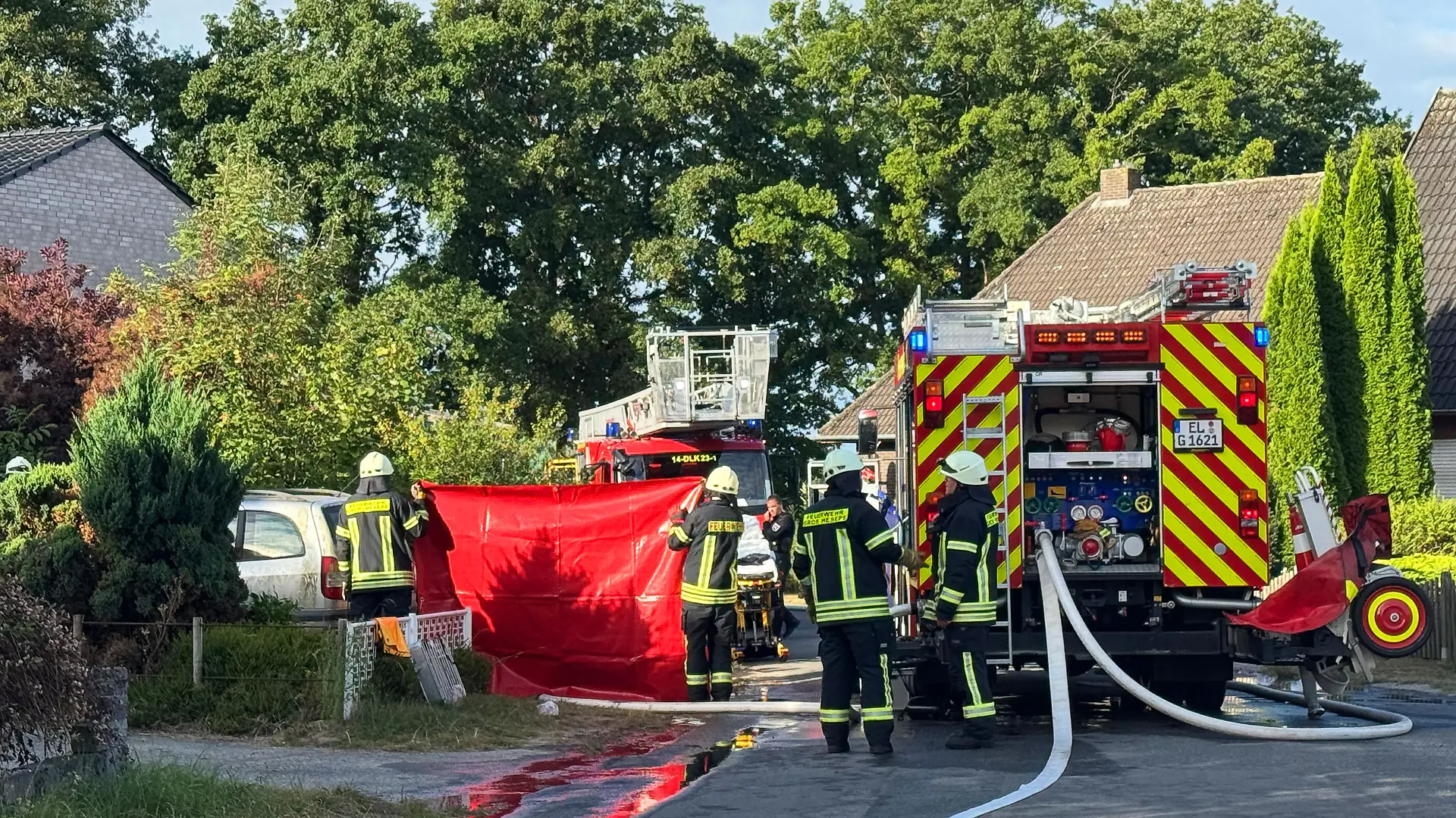 Einsatzkräfte der Feuerwehr stehen nach einem Wohnungsbrand im Landkreis Emsland vor einem Mehrfamilienhaus. Bei dem Wohnungsbrand ist ein Mann ums Leben gekommen. 