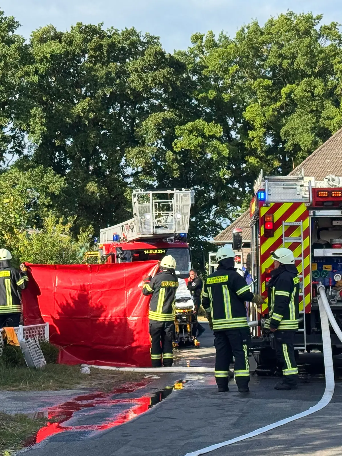 Einsatzkräfte der Feuerwehr stehen nach einem Wohnungsbrand im Landkreis Emsland vor einem Mehrfamilienhaus. Bei dem Wohnungsbrand ist ein Mann ums Leben gekommen. 