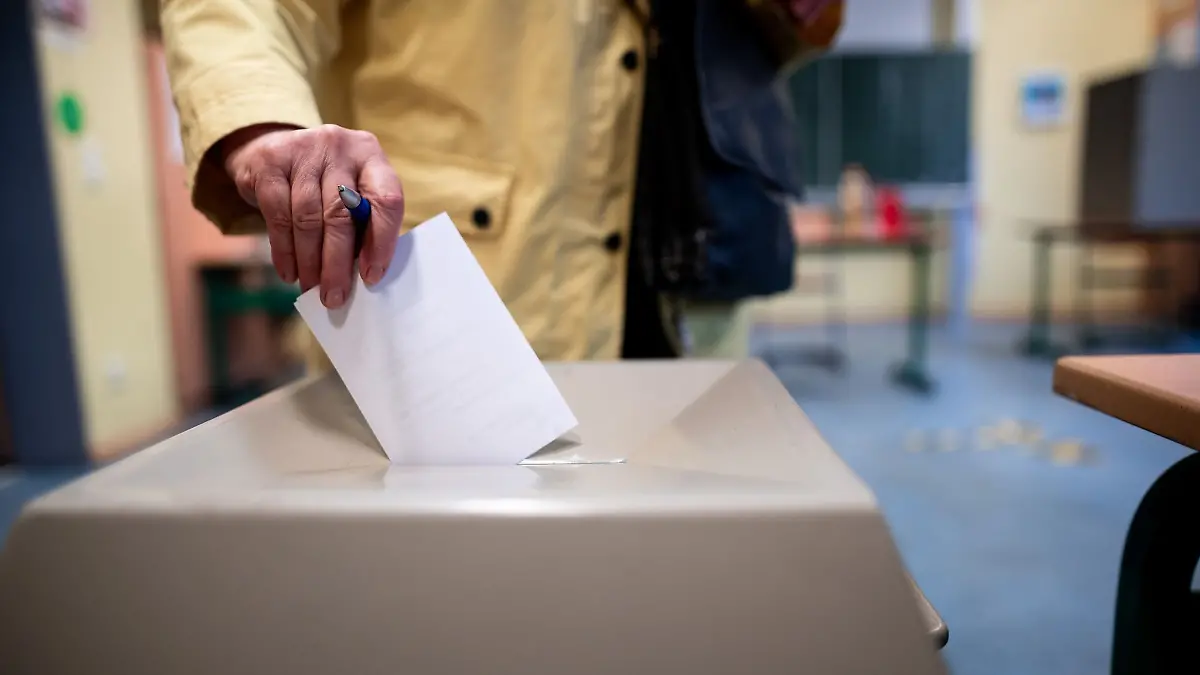 Eine Frau wirft einen Wahlschein in eine Wahlurne (Symbolbild)