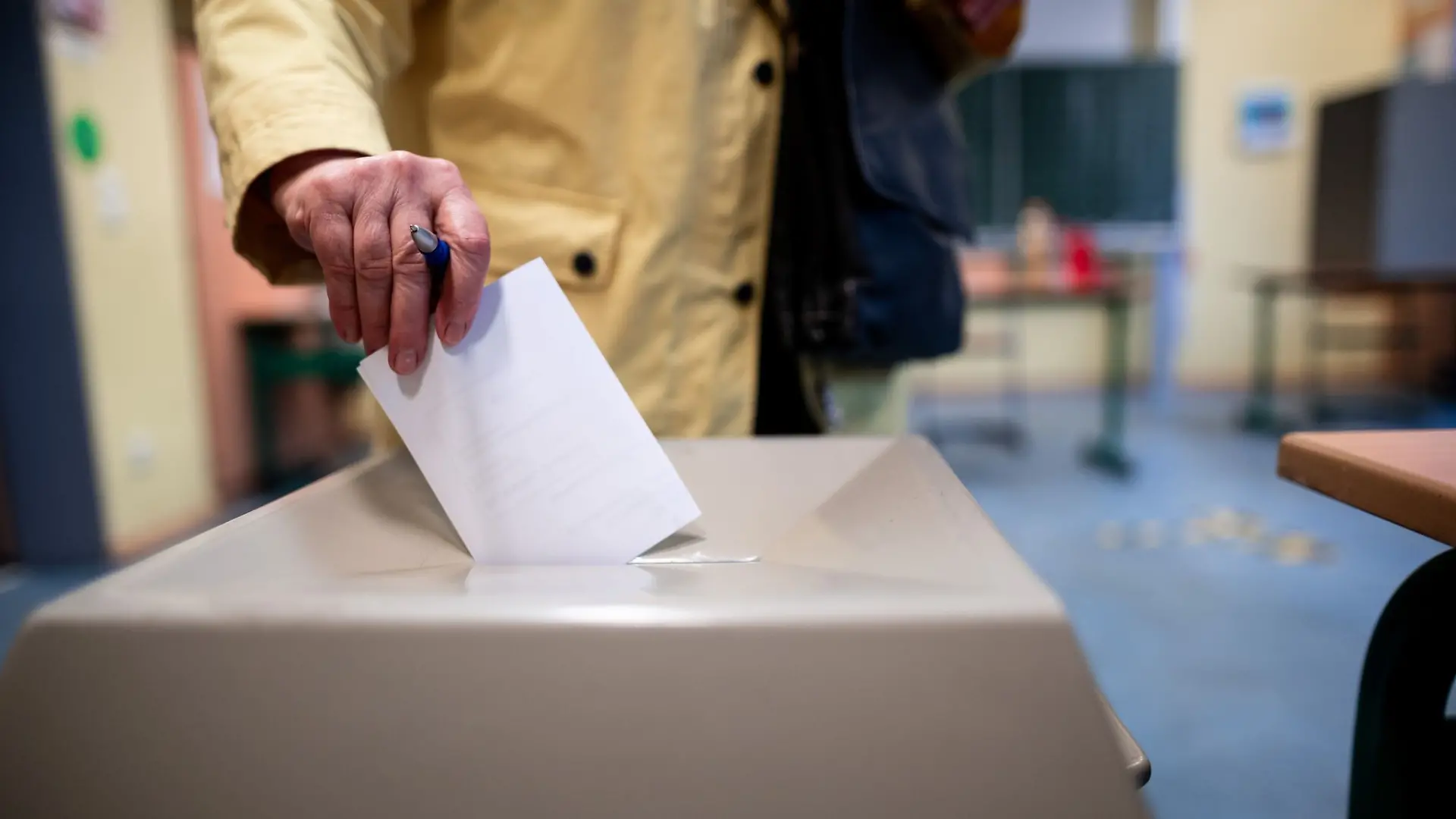 Eine Frau wirft einen Wahlschein in eine Wahlurne (Symbolbild)