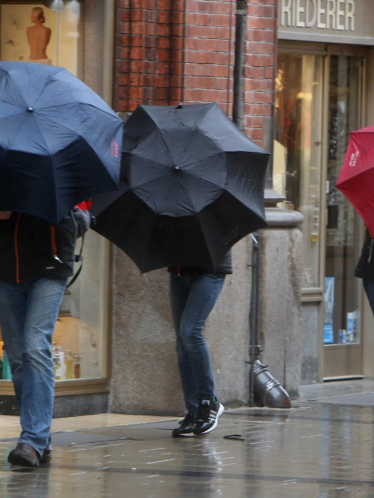 Ein Tiefdruckgebiet sorgt für Orkanböen und Regen in der Innenstadt München, Bayern, Deutschland: Personen kämpfen mit ihren Regenschirmen am Marienplatz *** A low-pressure area causes hurricanes and rain in downtown Munich Bavaria Germany People fight with their umbrellas at Marienplatz  