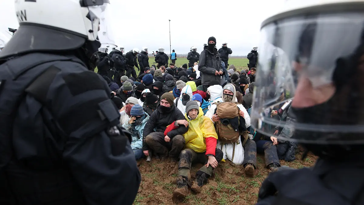 Police officers stop activists who stage a sit-in protest against the expansion of the Garzweiler open-cast lignite mine of Germany's utility RWE, in Luetzerath, Germany, January 11, 2023 that has highlighted tensions over Germany's climate policy during an energy crisis.  REUTERS/Thilo Schmuelgen