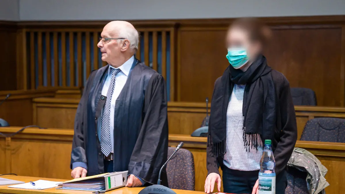 11.01.2023, Saarland, Saarbrücken: Die Frau, die ihre beiden Kinder von einem Balkon geworfen haben soll und anschließend selbst hinterher sprang, steht neben ihrem Anwalt Walter Teusch bei Beginn des Sicherungsverfahren im Landgericht Saarbrücken. Die Frau soll wegen einer psychischen Erkrankung schuldunfähig sein, in dem Verfahren geht es um die dauerhafte Unterbringung in einer speziellen psychiatrischen Einrichtung. Foto: Oliver Dietze/dpa - ACHTUNG: Person(en) wurde(n) aus rechtlichen Gründen gepixelt +++ dpa-Bildfunk +++