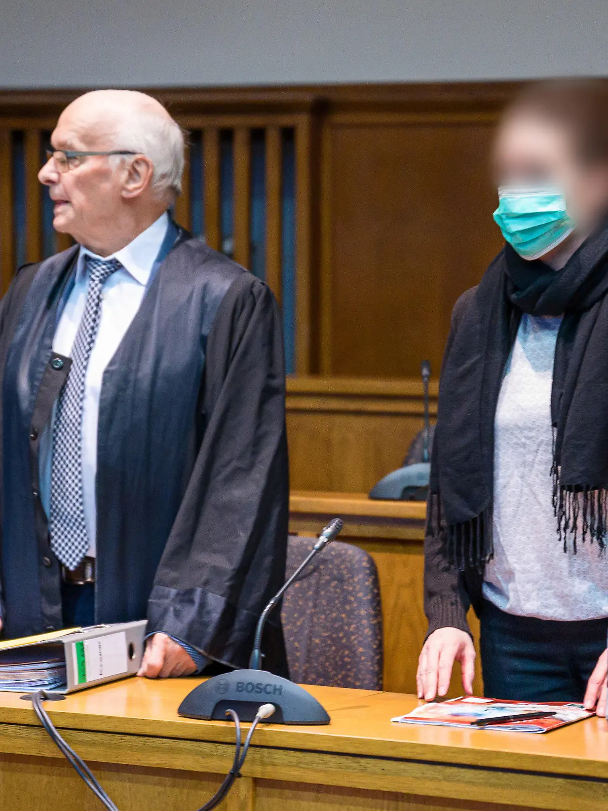 11.01.2023, Saarland, Saarbrücken: Die Frau, die ihre beiden Kinder von einem Balkon geworfen haben soll und anschließend selbst hinterher sprang, steht neben ihrem Anwalt Walter Teusch bei Beginn des Sicherungsverfahren im Landgericht Saarbrücken. Die Frau soll wegen einer psychischen Erkrankung schuldunfähig sein, in dem Verfahren geht es um die dauerhafte Unterbringung in einer speziellen psychiatrischen Einrichtung. Foto: Oliver Dietze/dpa - ACHTUNG: Person(en) wurde(n) aus rechtlichen Gründen gepixelt +++ dpa-Bildfunk +++
