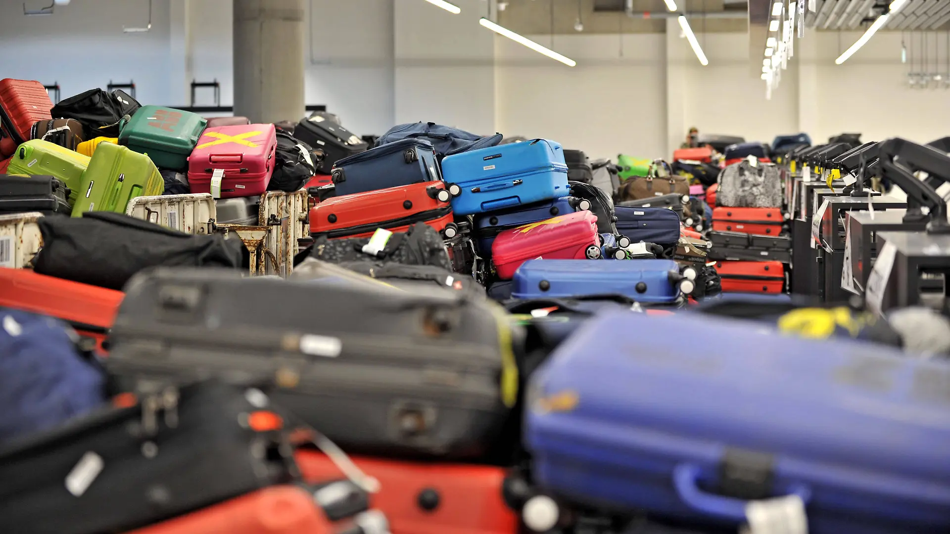 Unzählige aufgegebene Koffer am Flughafen, mit und ohne Kofferbänder