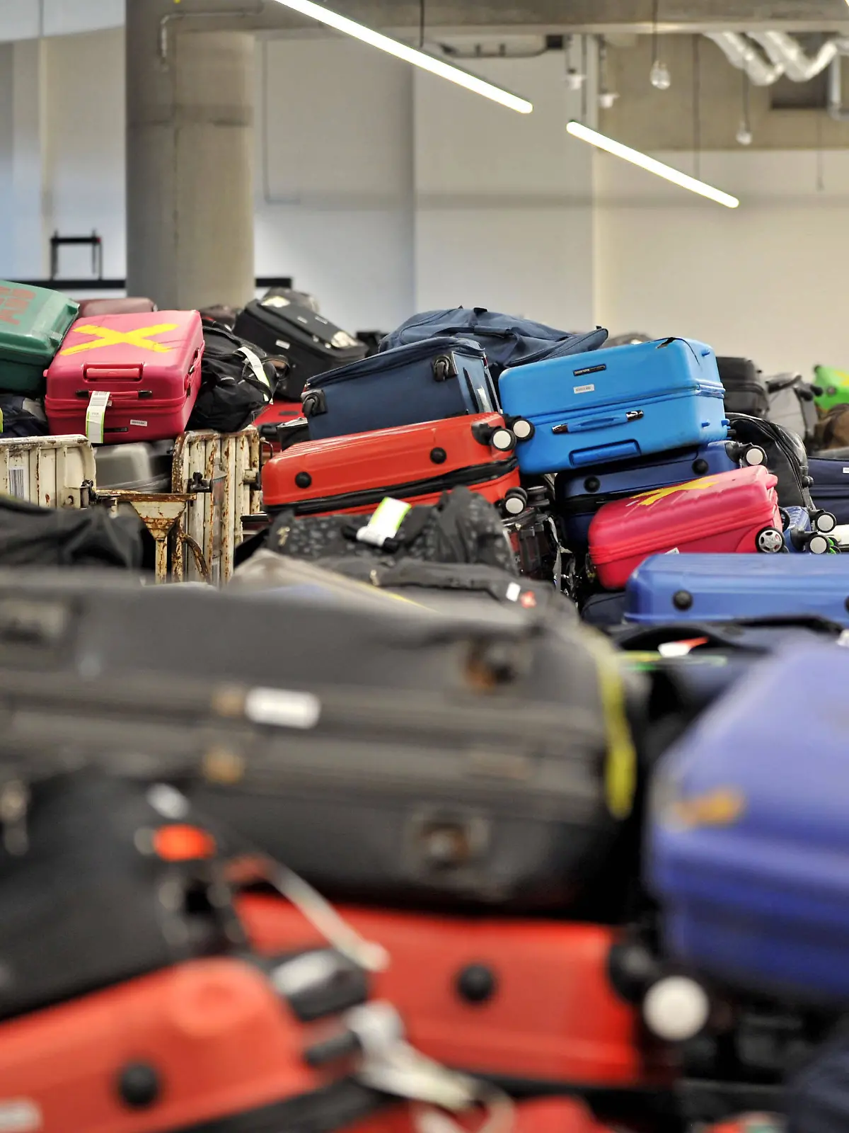 Unzählige aufgegebene Koffer am Flughafen, mit und ohne Kofferbänder