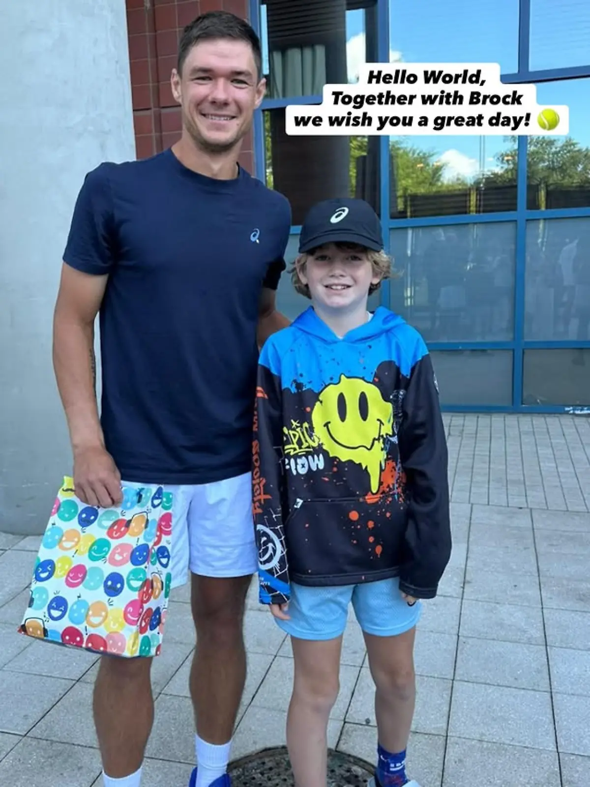Kamil Majchrzak steht bei den US-Open neben einem Jungen namens Brock, daneben steht: „Hello world, together with Brock we wish you a great day.”