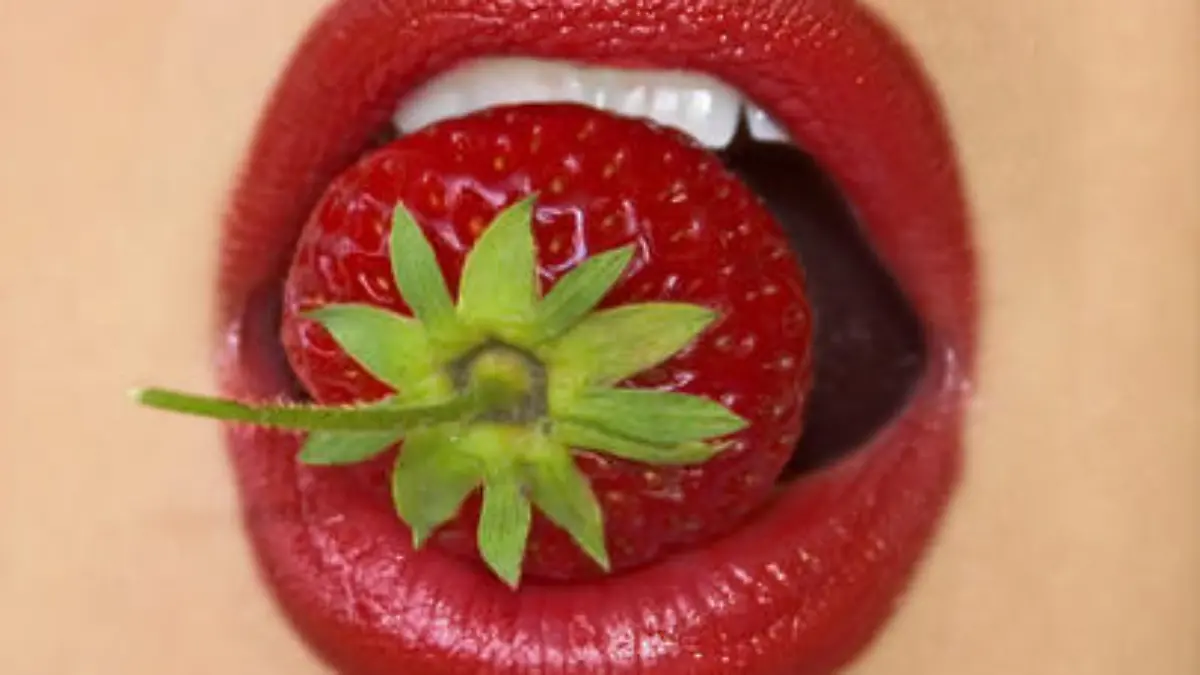 red lips eating strawberry close-up