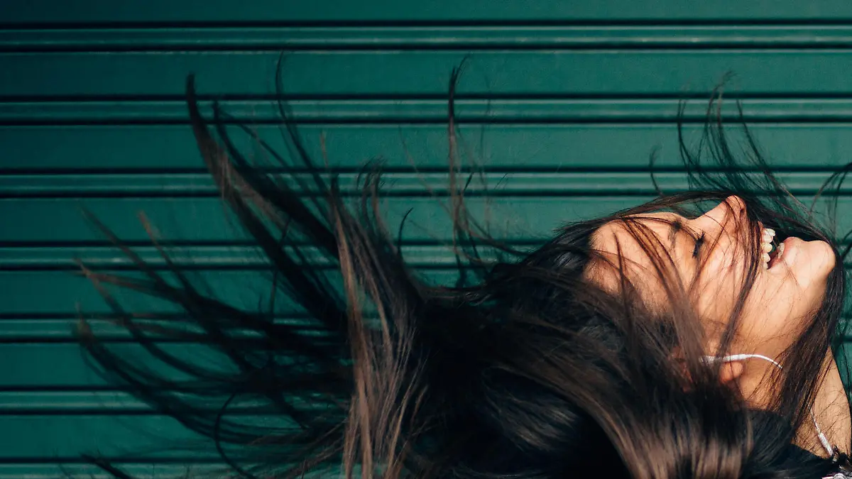 Young woman tossing hair while enjoying the music