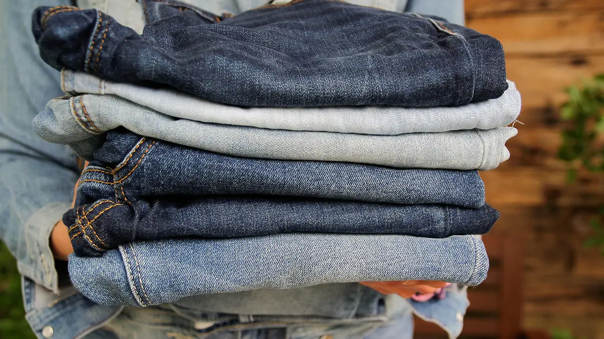 Jeans gestapelt in der Hand einer Frau