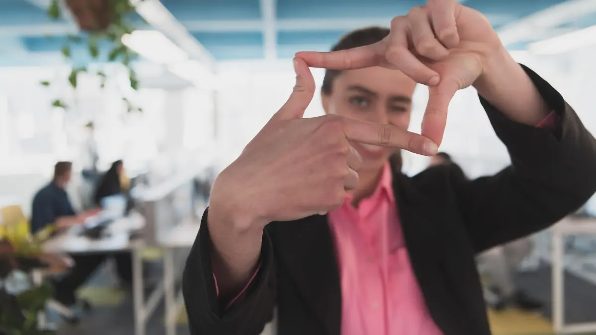 Closeup of hands, Smiling Business Woman Making Frame Gesture with at modern bright coworking open space startup office || Modellfreigabe vorhanden
