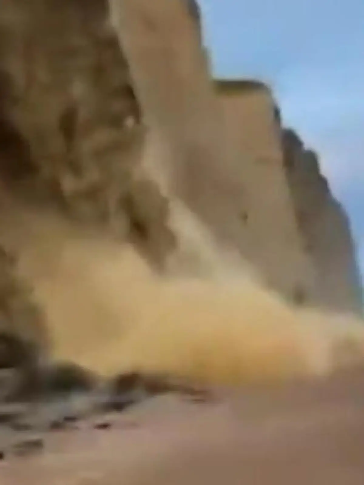 Mehrere Menschen gehen am Strand am West Bay in England spazieren - dann rauscht plötzlich ein Teil der Klippe in die Tiefe!