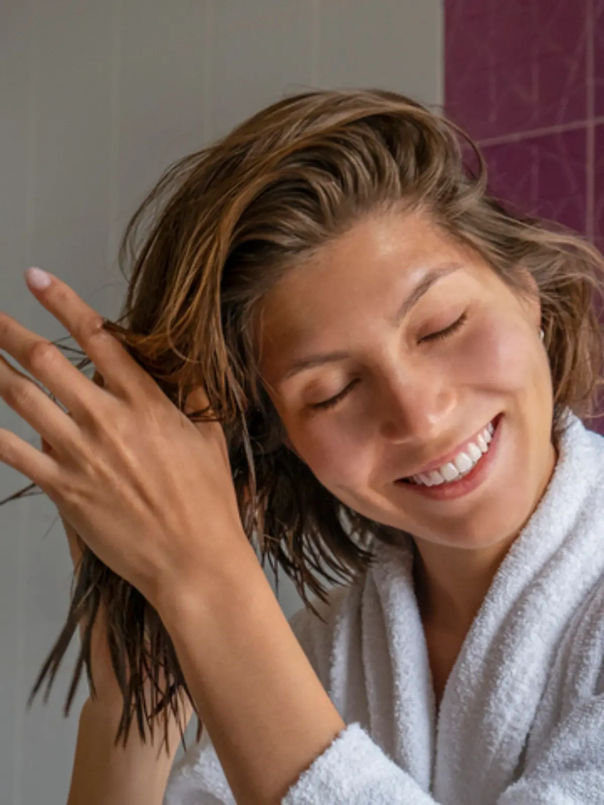 Junge Frau trägt Leave-in Conditioner auf