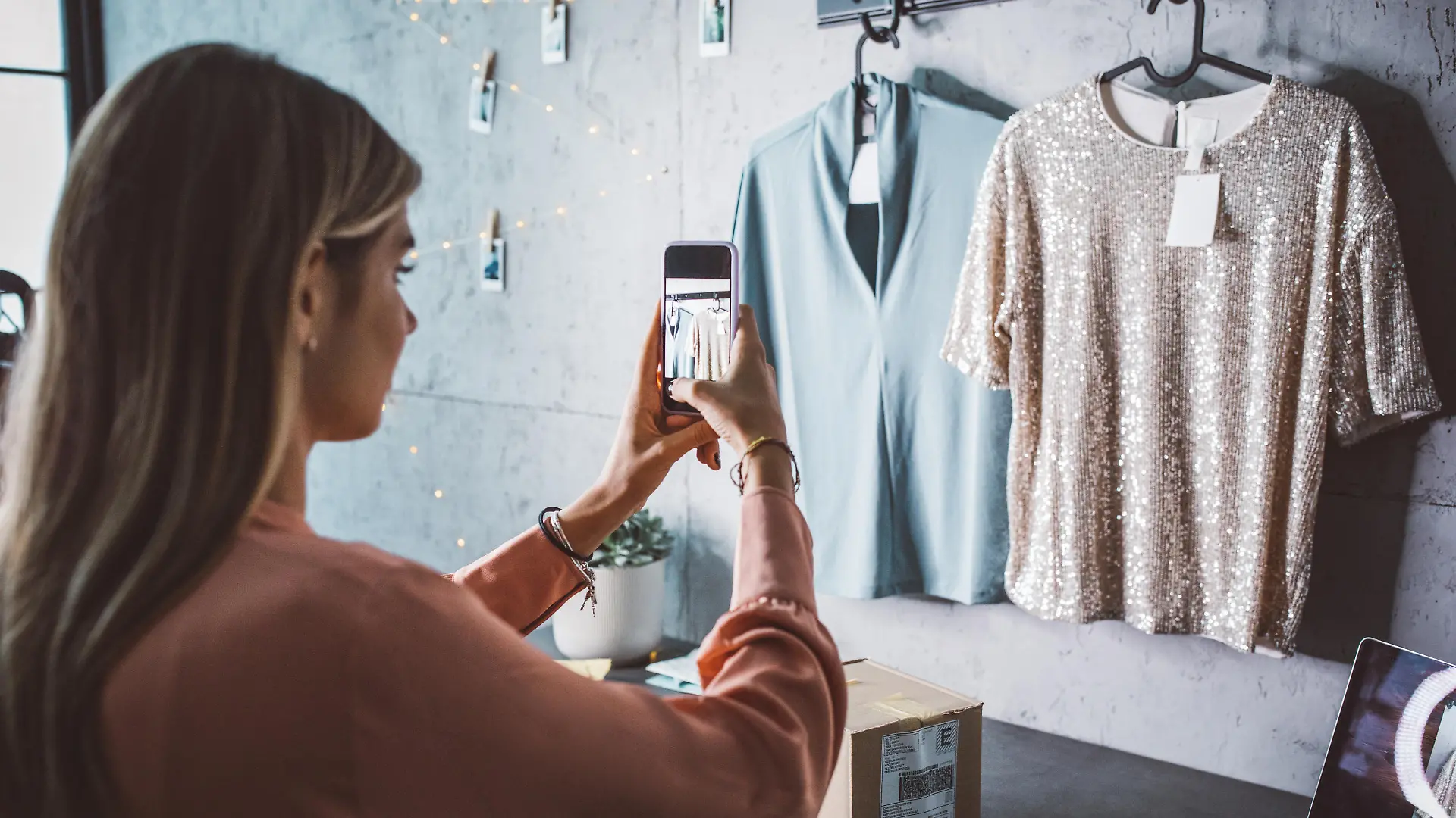 Young woman at online shop. She is owner of small online shop. Photographing new clothes for online store.