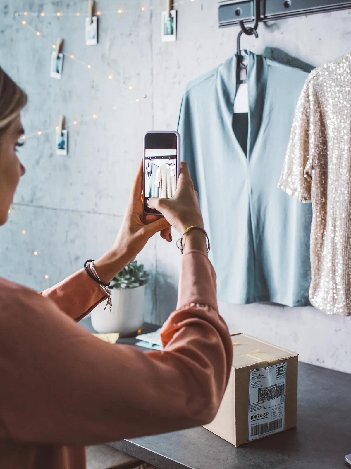 Young woman at online shop. She is owner of small online shop. Photographing new clothes for online store.