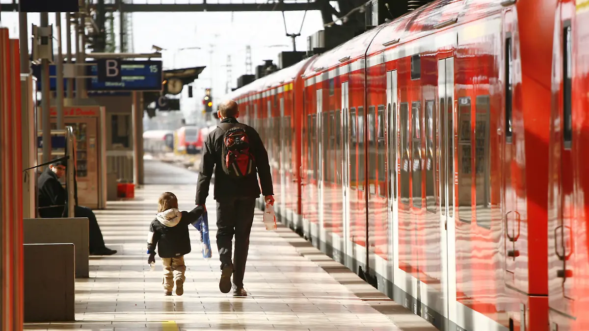 Ein Vater und sein kleiner Sohn gehen über einen Bahnsteig neben einem Zug der Deutschen Bahn zu ihrem Waggon im Hauptbahnhof in Frankfurt am Main am 18.03.2008. Die beiden haben leichtes Gepäck dabei und der Mann hält das Kind an der Hand. Foto: Wolfram Steinberg +++(c) dpa - Report+++