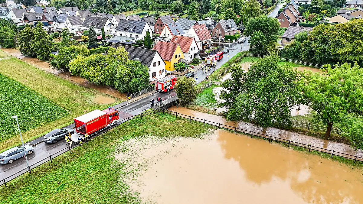 Bei einem über die Ufer getretenen Bach sind Einsatzkräfte der Feuerwehr im Einsatz.