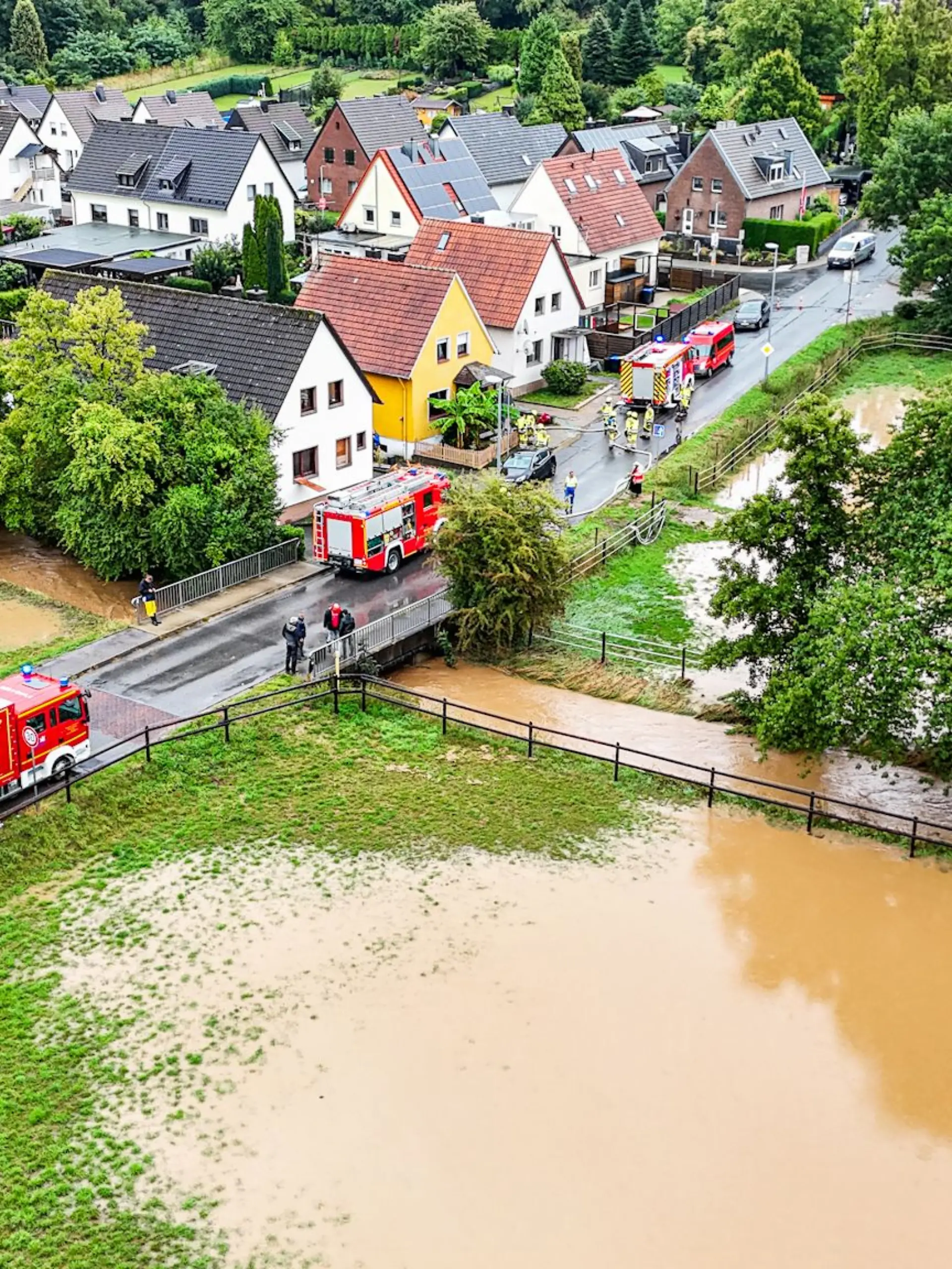 Bei einem über die Ufer getretenen Bach sind Einsatzkräfte der Feuerwehr im Einsatz.
