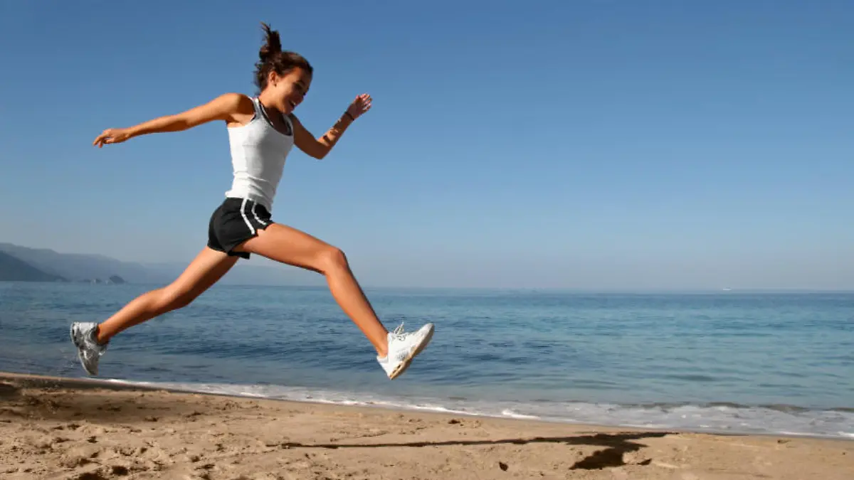 Happy girl running alone on the beach
