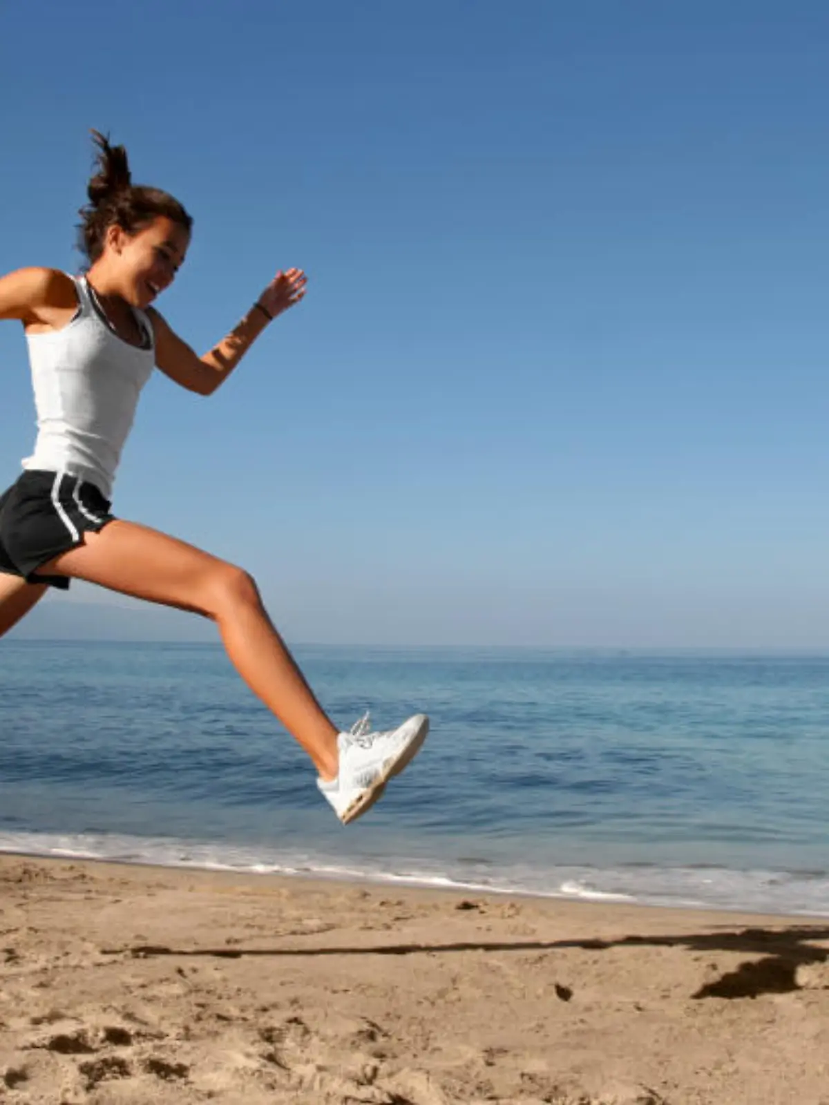 Happy girl running alone on the beach
