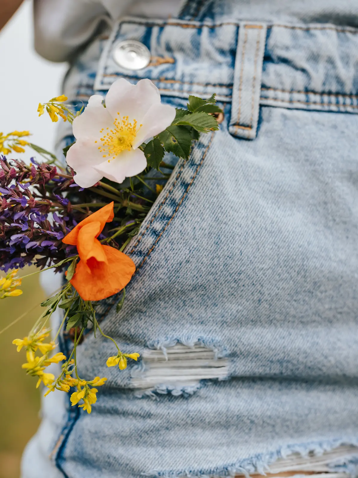 Jeans mit Blumen in der Tasche.