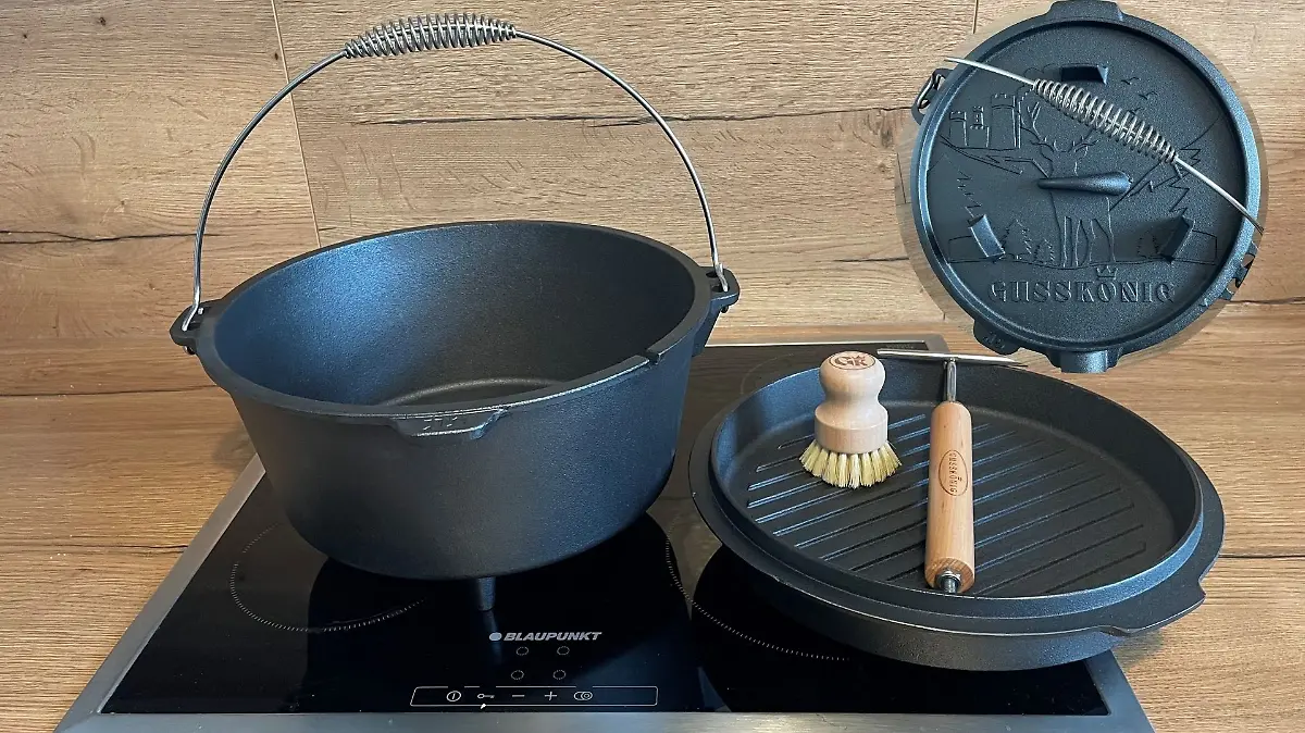 Dutch Oven steht auf dem Herd. Decke und Zubehör sind auch auf dem Bild zu sehen. 